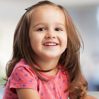 smiling girl doing crafts at a Preschool & Daycare Serving Carmel, Indiana