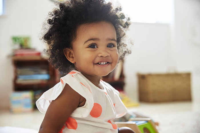 Happy Baby Girl Playing With Toys In Playroom at a Preschool & Daycare Serving Carmel, Indiana