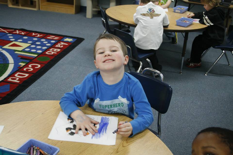 smiling boy coloring at a Preschool & Daycare Serving Carmel, Indiana