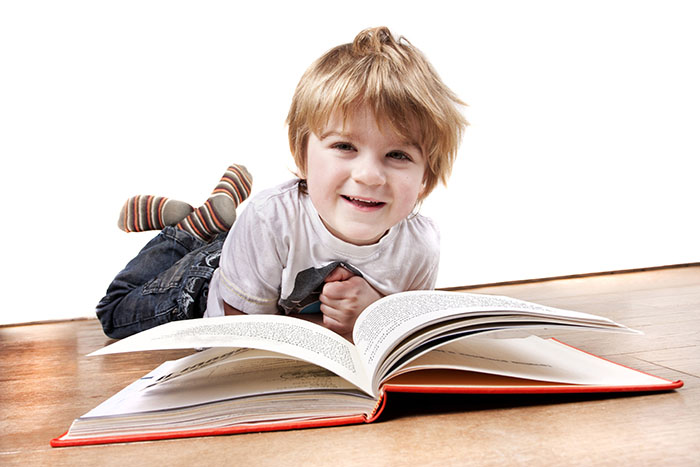 4 year old boy reading a book at a Preschool & Daycare Serving Carmel, Indiana